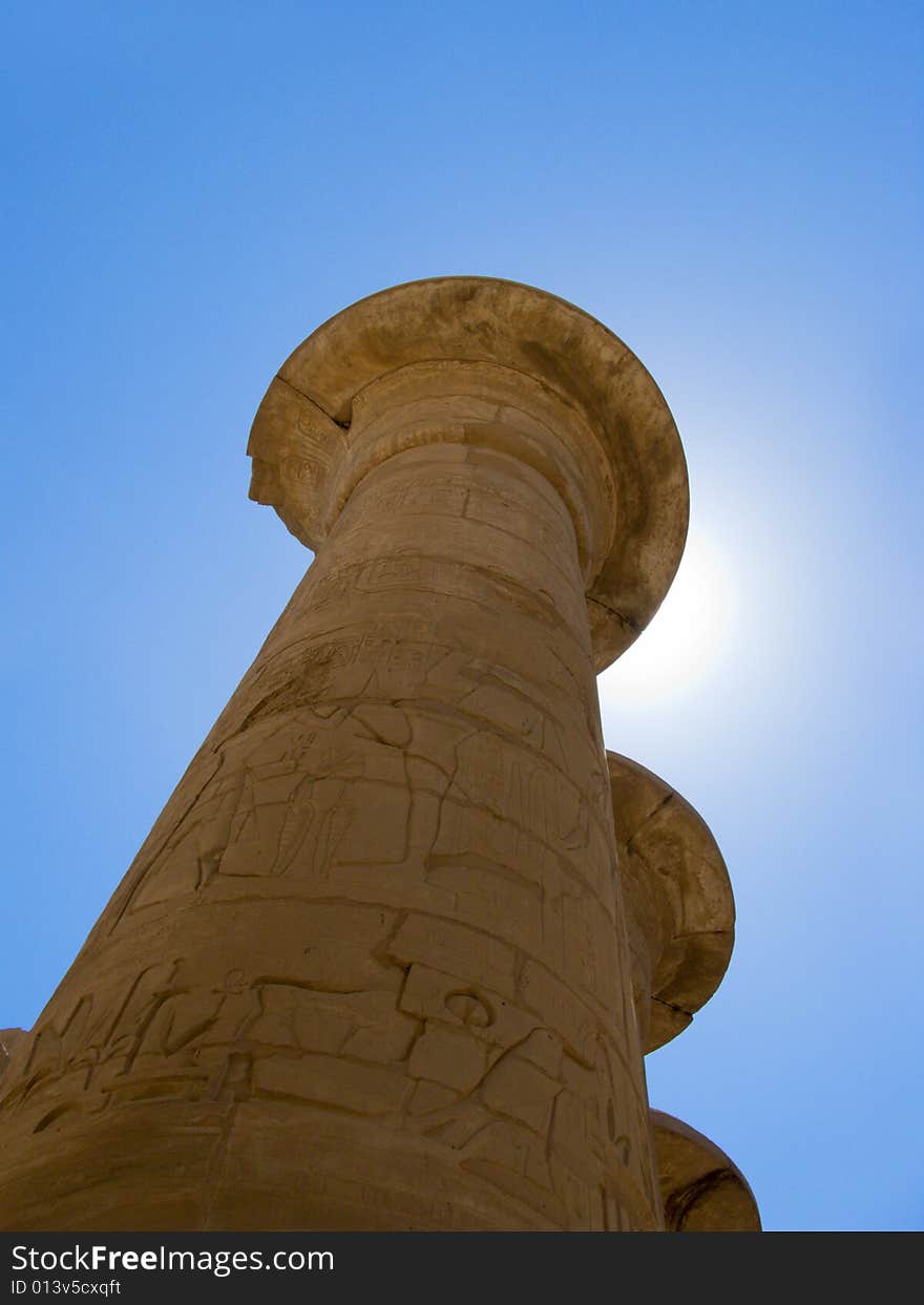 Egyptian column in luxor temple with blue sky and sun. Egyptian column in luxor temple with blue sky and sun