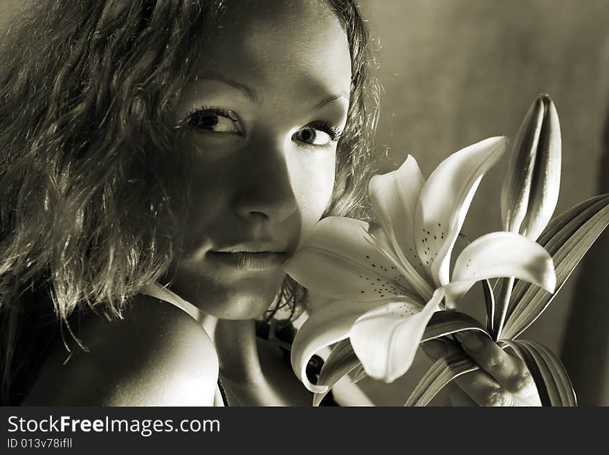 Beautiful girl with lilly. Low DOF, focus on eyes and flower