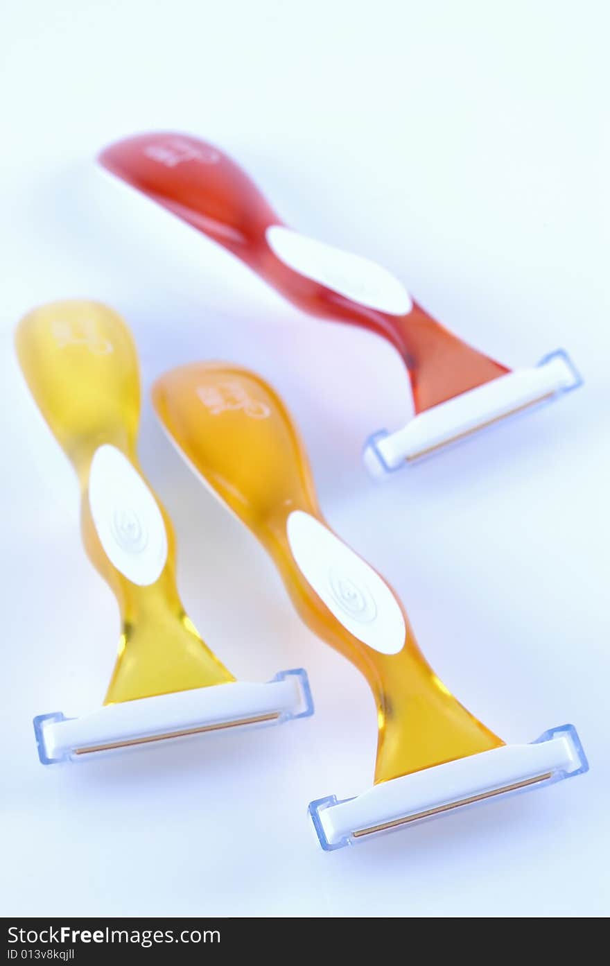 Three shavers on a pale blue background with selective focus