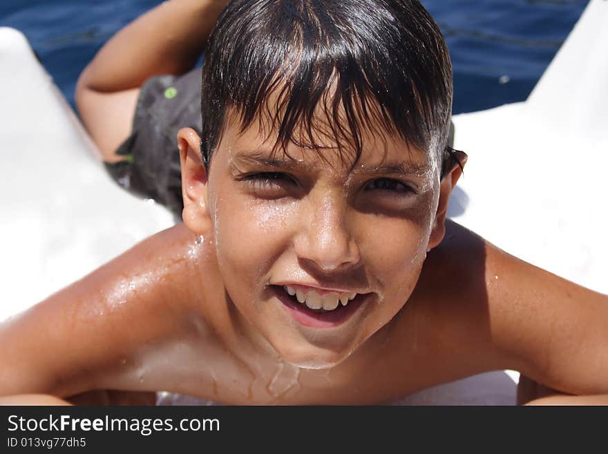 Smiling boy coming out of the water during summer sports. Smiling boy coming out of the water during summer sports