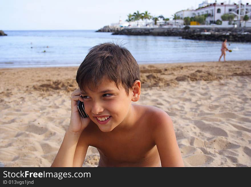 Child talking in the cellular by the seaside. Child talking in the cellular by the seaside