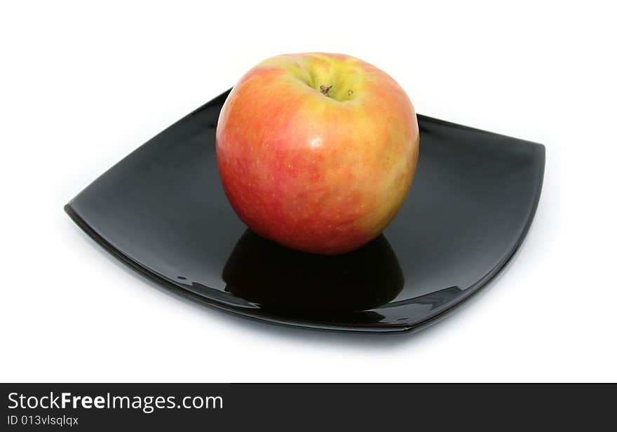 Ripe apple on a black plate