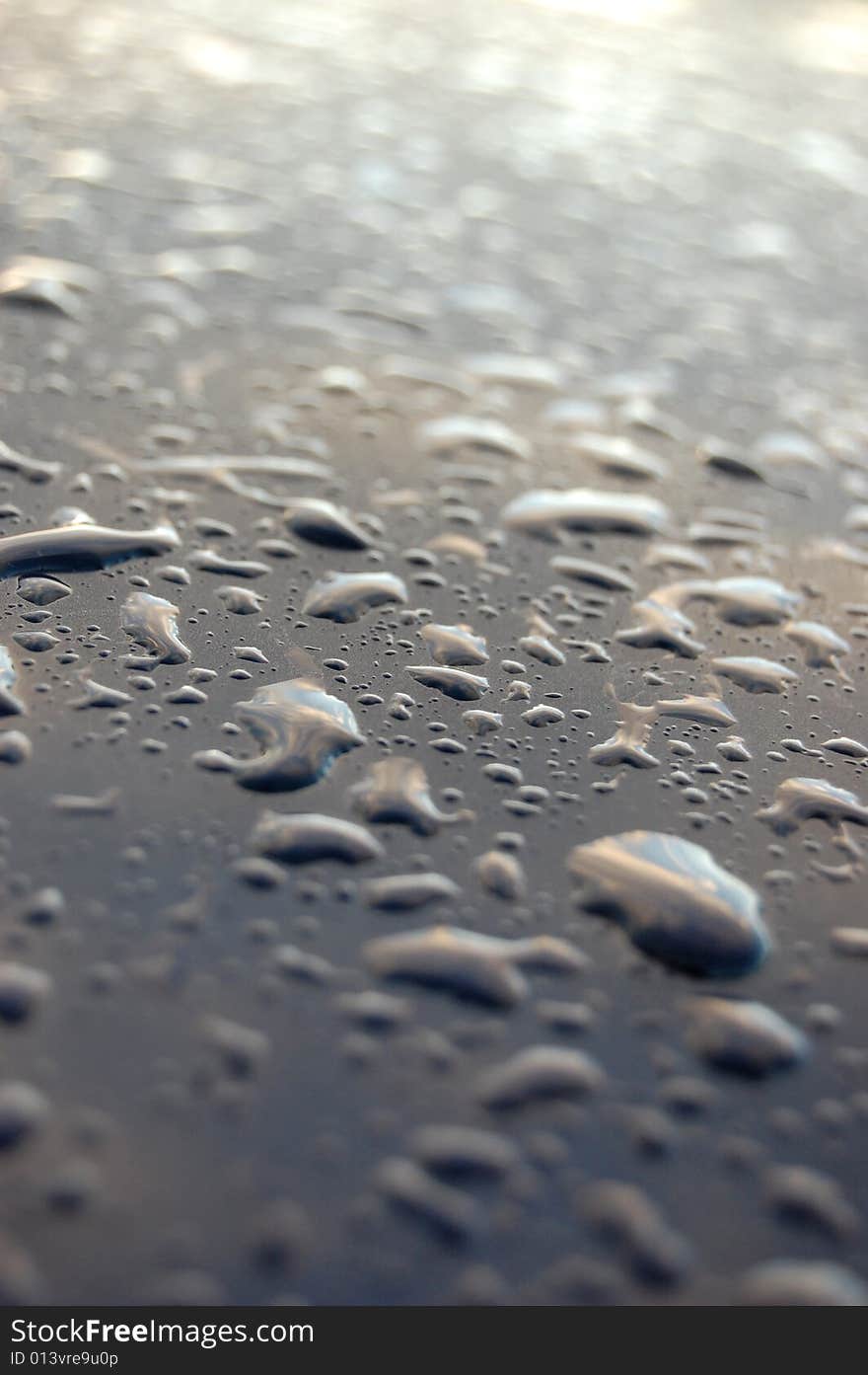 Small water drop on blue metal car hood. Small water drop on blue metal car hood