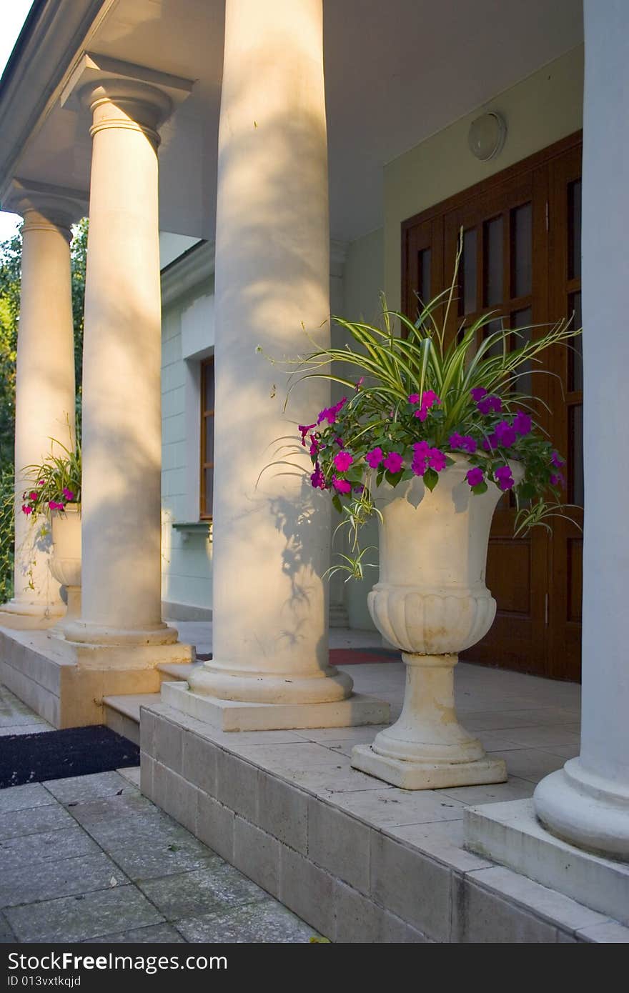 Main entry of old building with flowers at evening lights in Russia