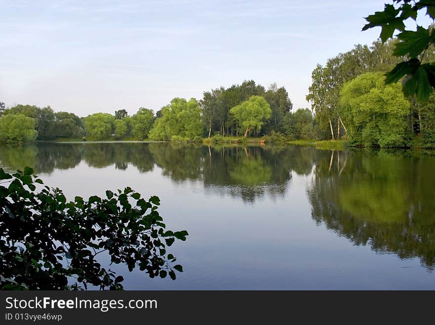 Big pond in town outside forest . Summer time. Big pond in town outside forest . Summer time.