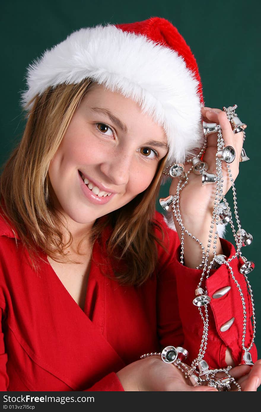 Teenager in red holding a silver string with bells. Teenager in red holding a silver string with bells