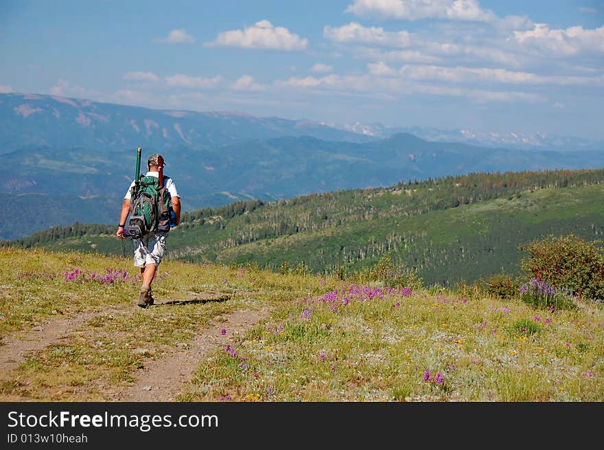 A hiker with a backpack hiking in the Colorado mountains.