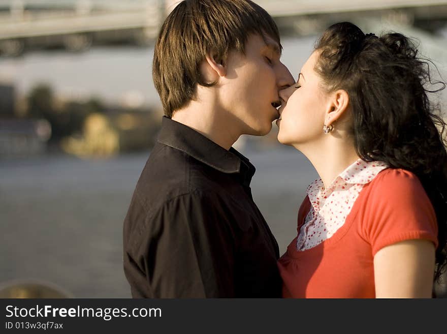 Outdoor portrait of young loving couple kissing each other