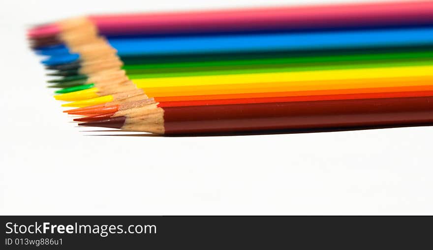 Rows of brightly colored pencils in a horizontal rainbow pattern facing right while isolated on a white background. Rows of brightly colored pencils in a horizontal rainbow pattern facing right while isolated on a white background