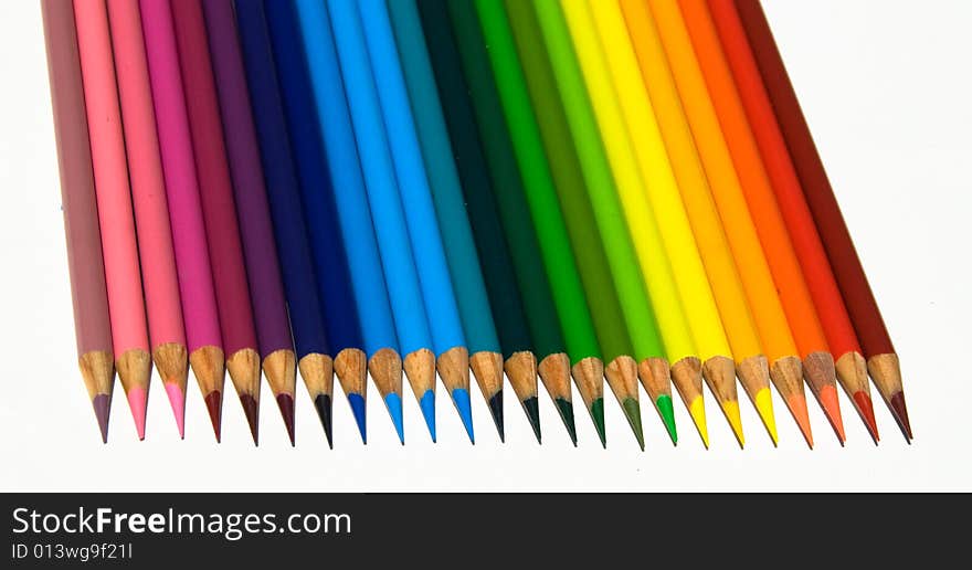 Rows of sharp and brightly colored pencils in a rainbow pattern facing downward while isolated on a white background. Rows of sharp and brightly colored pencils in a rainbow pattern facing downward while isolated on a white background