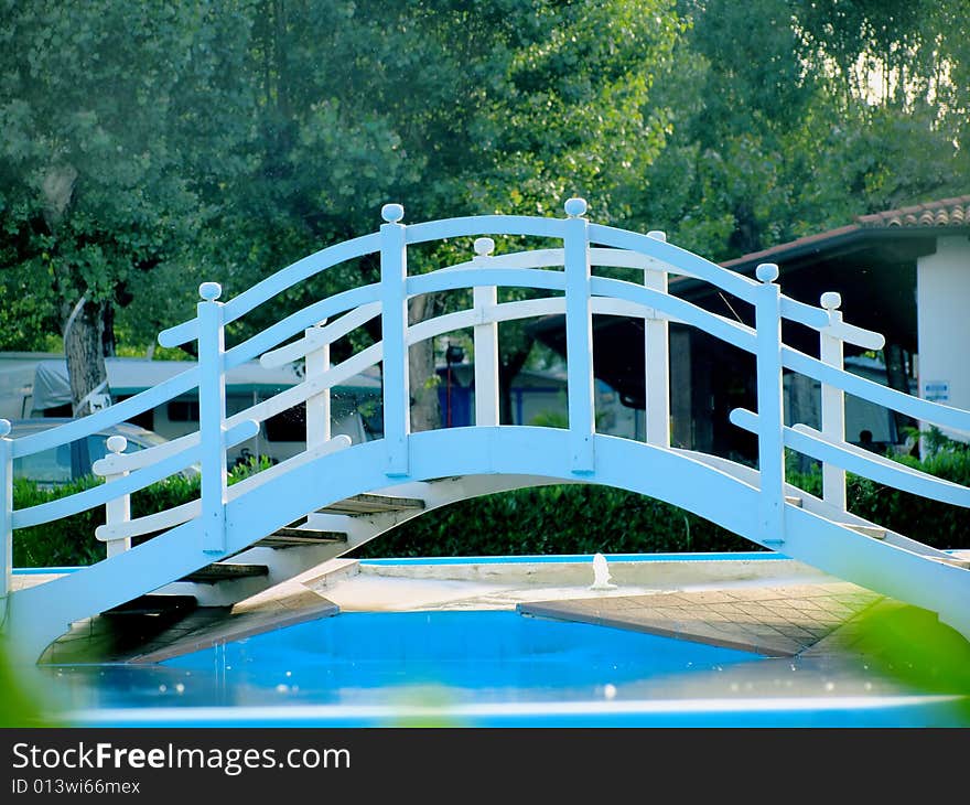 A funny blue bridge across a pool