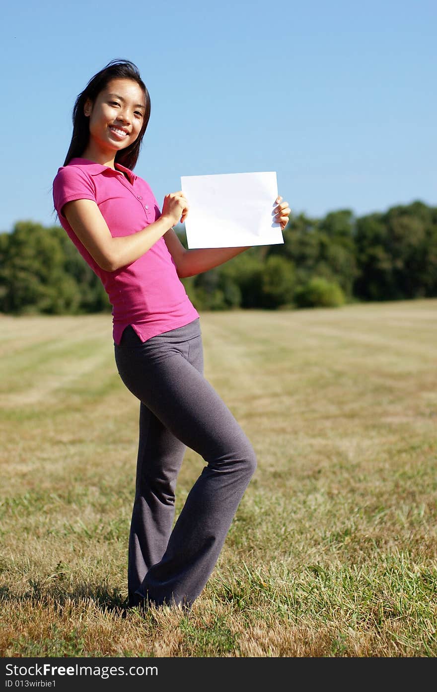 Girl with blank sign standing in a field. Girl with blank sign standing in a field.