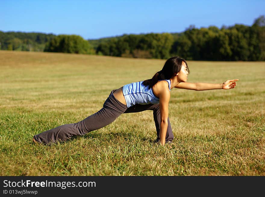 Girl Practicing Yoga In Field