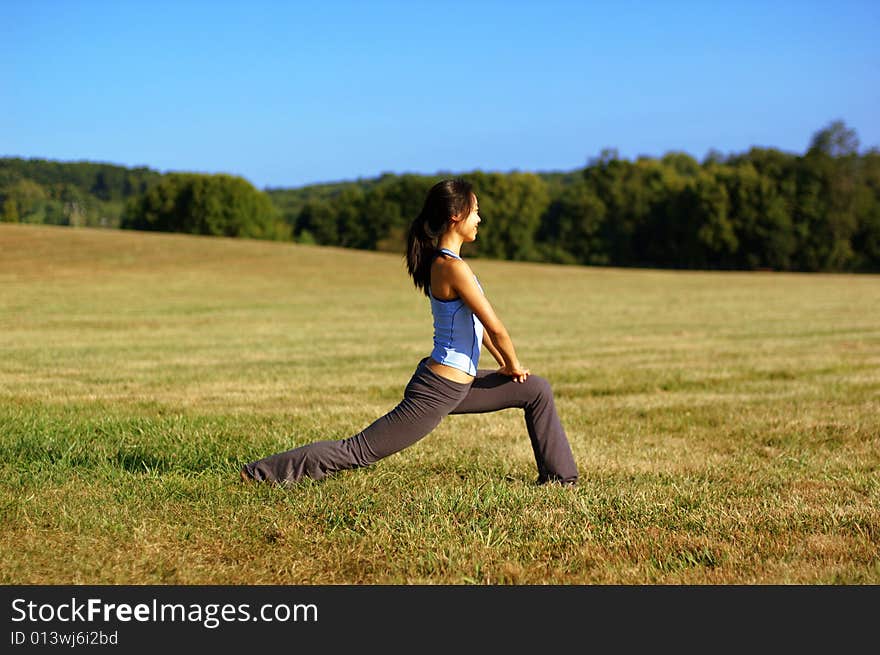 Girl Practicing Yoga In Field