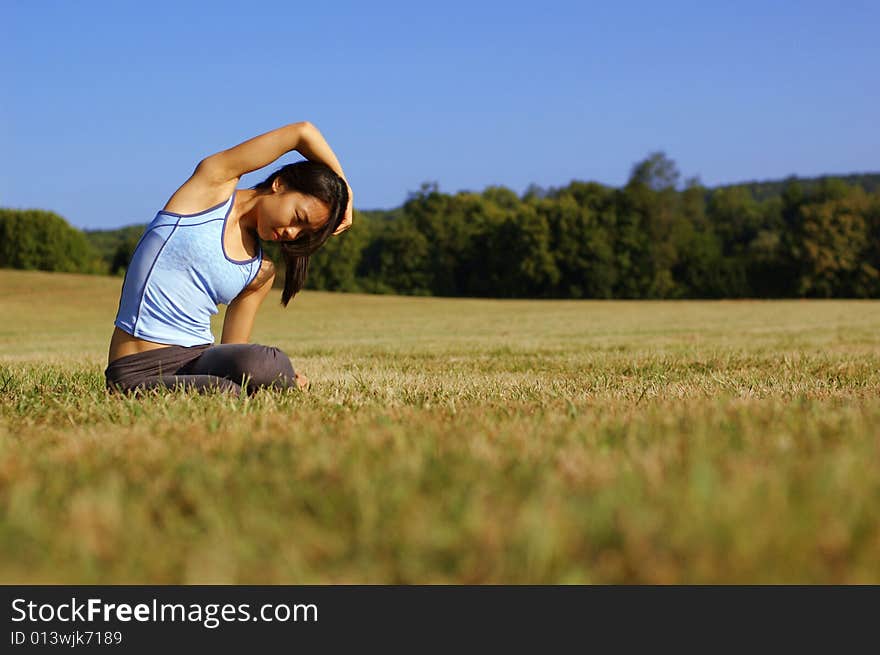 Girl Practicing Yoga In Field