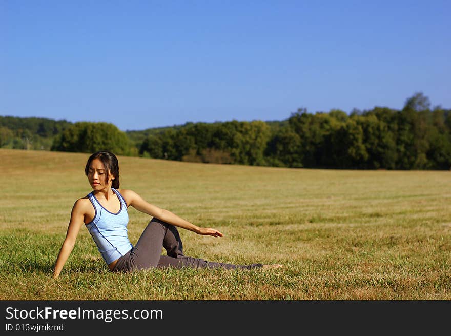 Girl Practicing Yoga In Field