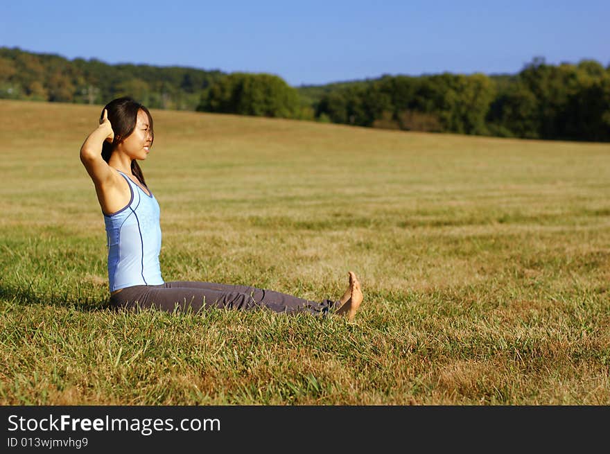 Girl Practicing Yoga In Field