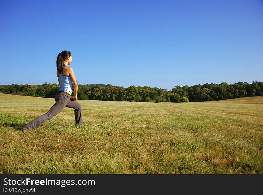 Girl Practicing Yoga In Field