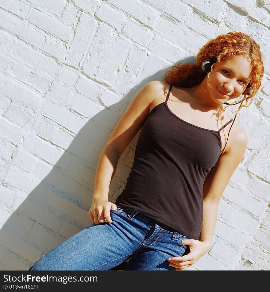 Attractive urban girl against white brick wall.