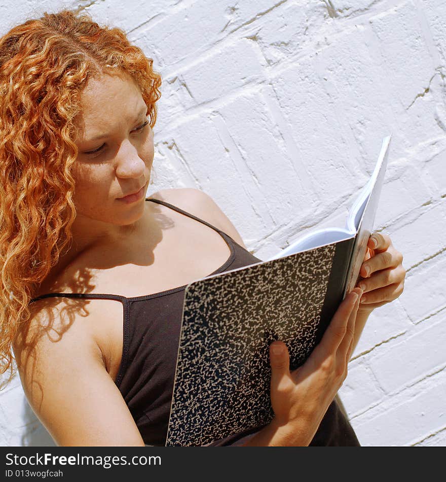 Attractive urban girl against white brick wall.