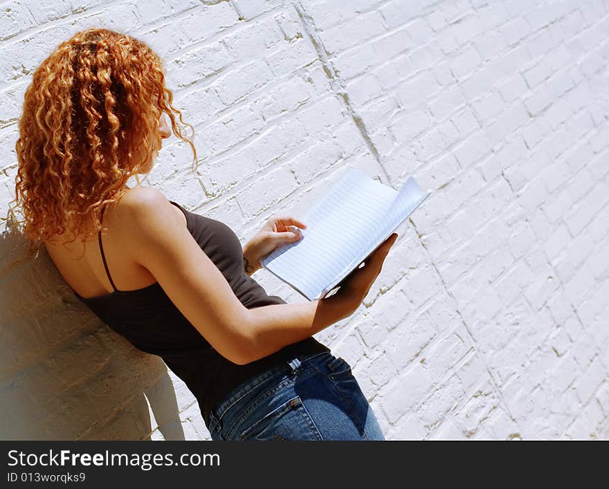 Attractive urban girl against white brick wall.