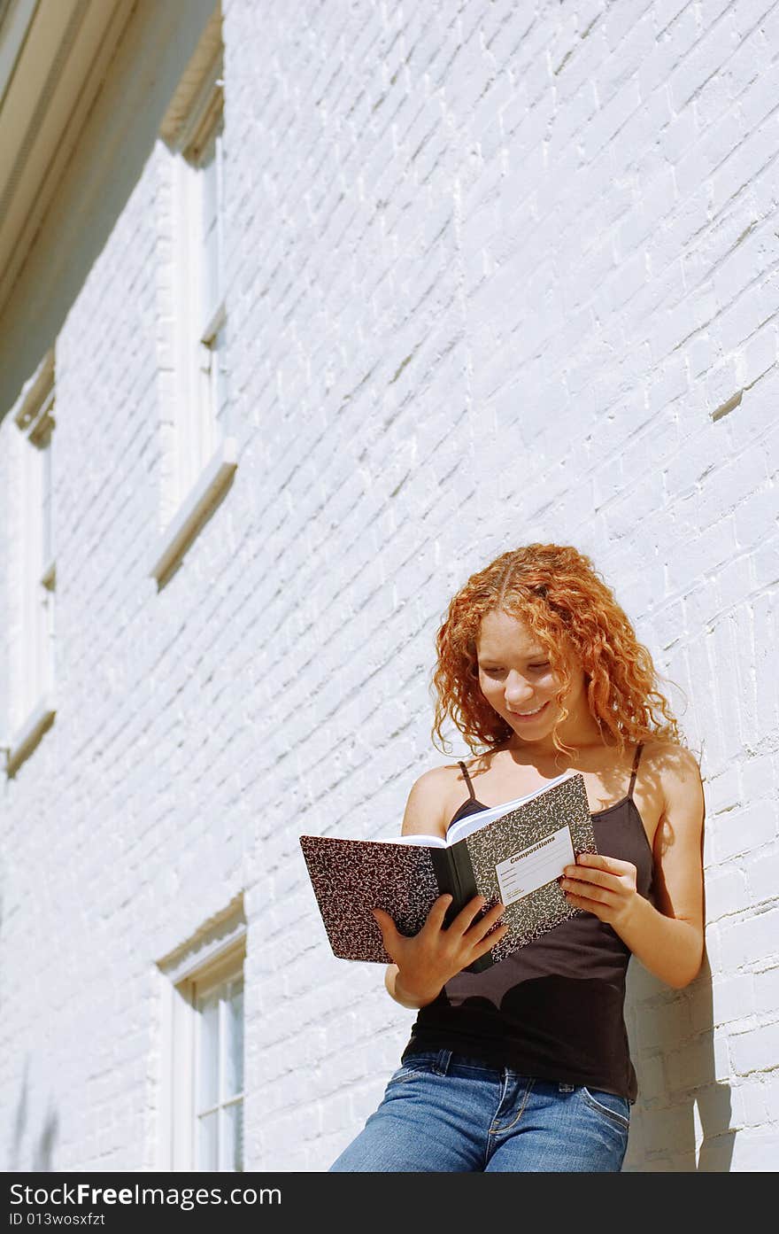 Attractive urban girl against white brick wall.