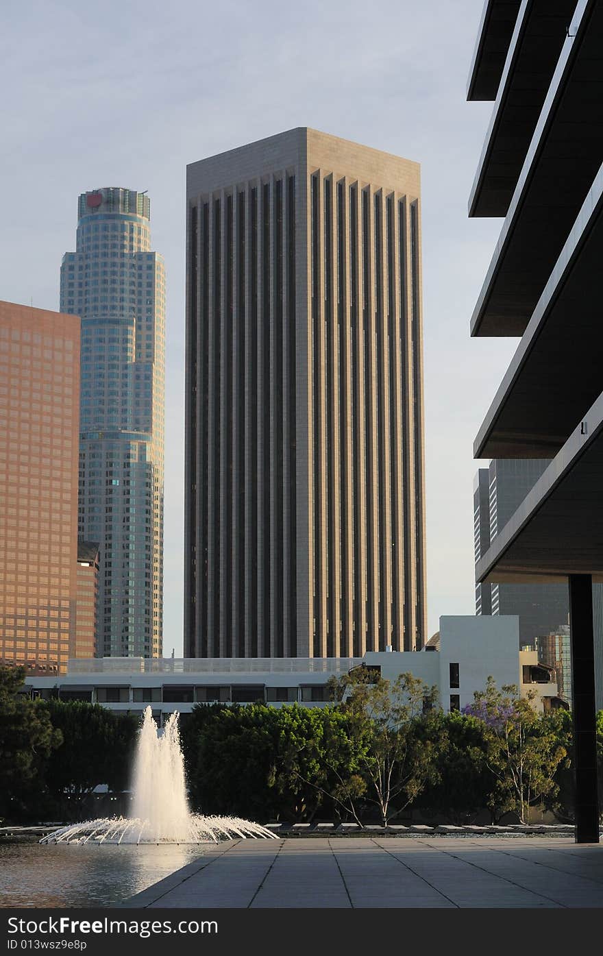 Tall skyscrapers tower above a plaza with fountains in downtown Los Angeles. Tall skyscrapers tower above a plaza with fountains in downtown Los Angeles