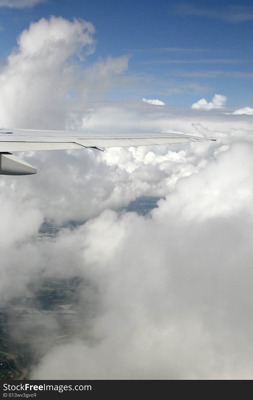 An aircraft wing with many white clouds