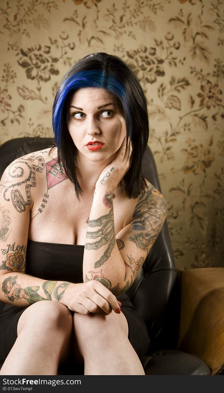 Pretty Woman with Tattoos in a Leather Chair