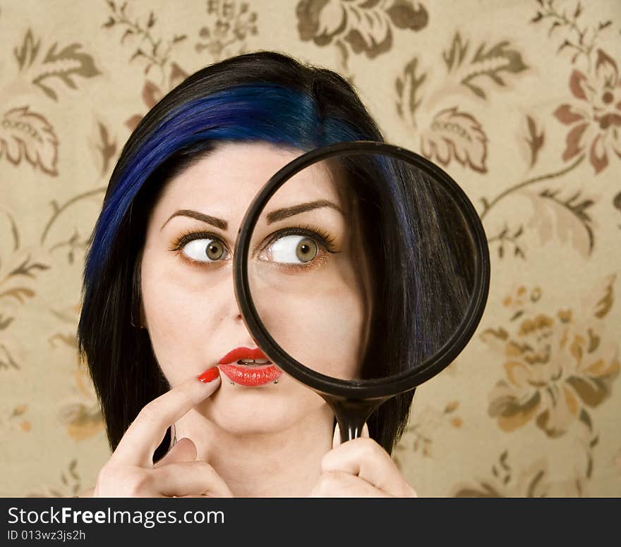 Pretty Woman Holding a magnifying Glass to her Face. Pretty Woman Holding a magnifying Glass to her Face