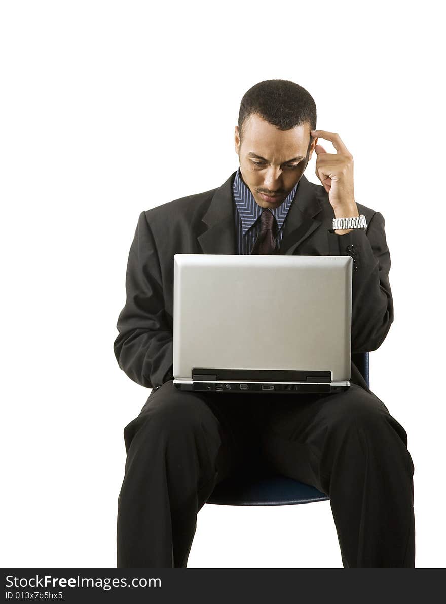 A young professional African-American male working on a laptop. A young professional African-American male working on a laptop.