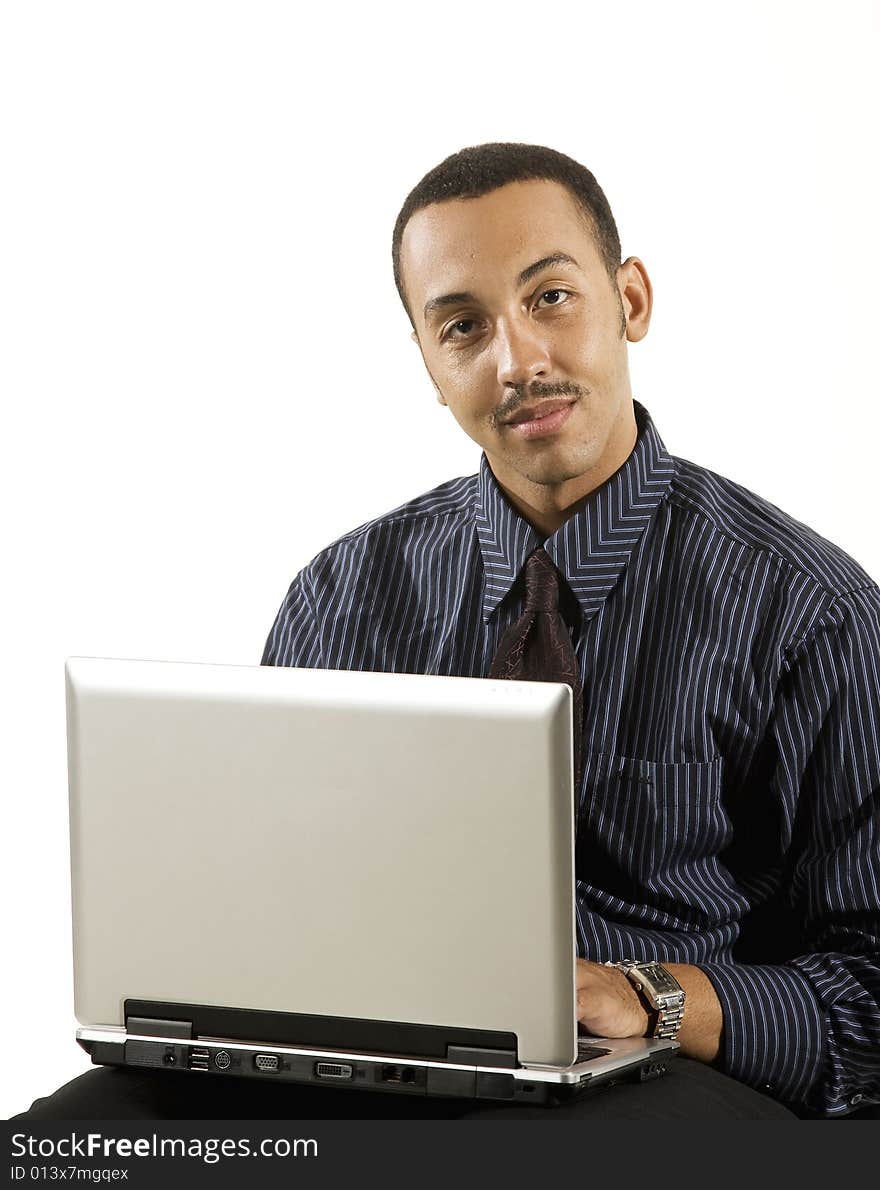 A young professional African-American male working on a laptop. A young professional African-American male working on a laptop.