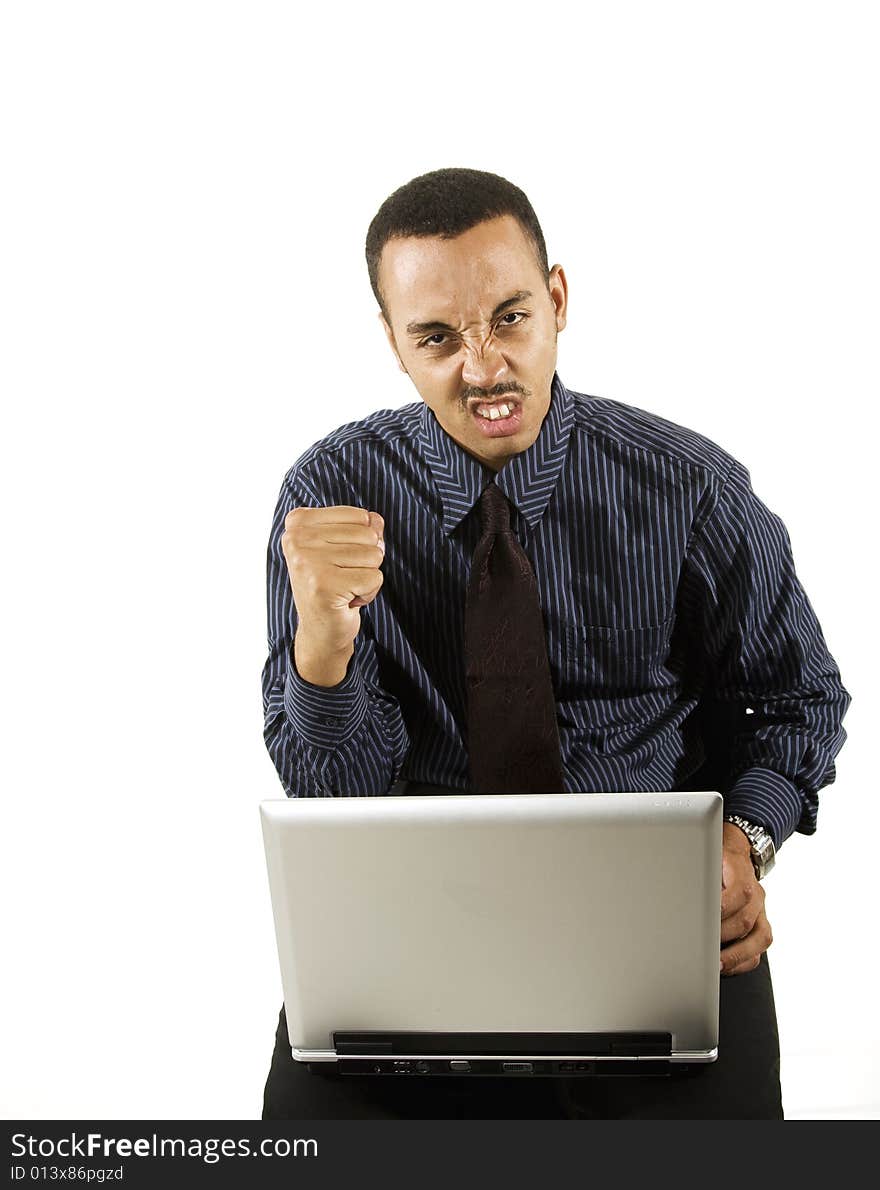 A young professional African-American male working on a laptop. A young professional African-American male working on a laptop.