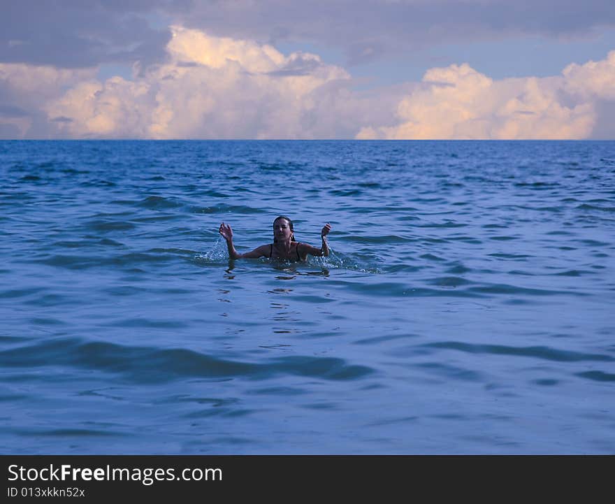 Woman submerging from the water on an overcast day