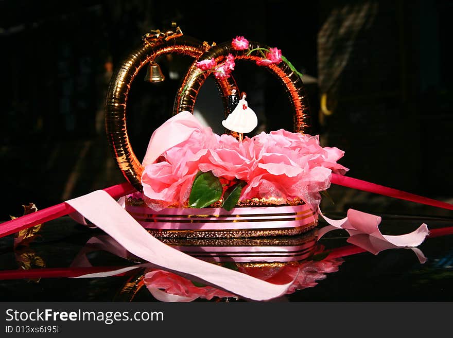 Wedding rings on the top of car, doll of bridegroom and bride, pink ribbons. Wedding rings on the top of car, doll of bridegroom and bride, pink ribbons