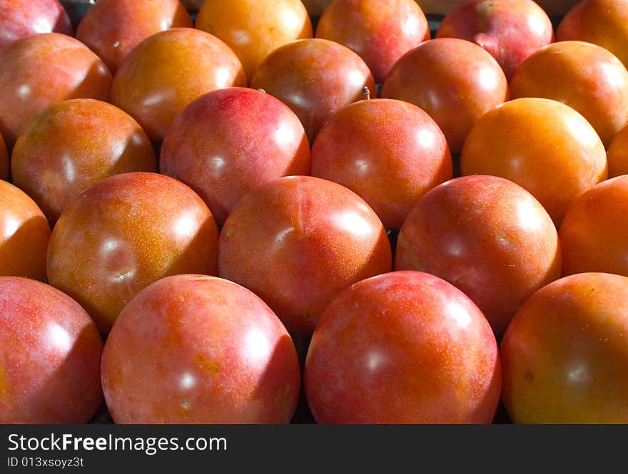 Red plums lined up in a crate. Red plums lined up in a crate