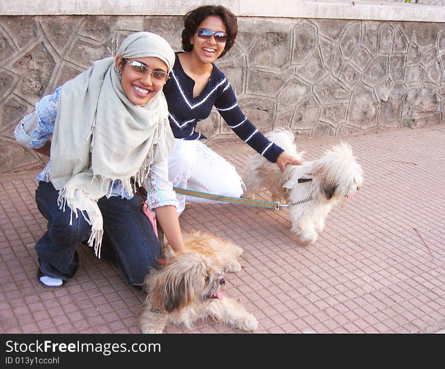 Two Indian Babes playing with Two shaggy pet dogs. Two Indian Babes playing with Two shaggy pet dogs