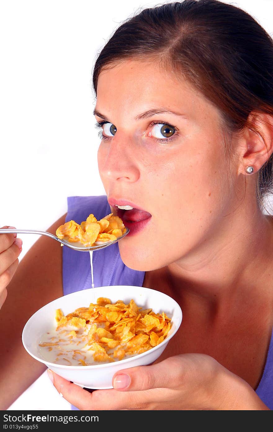 A young woman enjoys her crunchy cornflakes. Isolated over white. A young woman enjoys her crunchy cornflakes. Isolated over white.