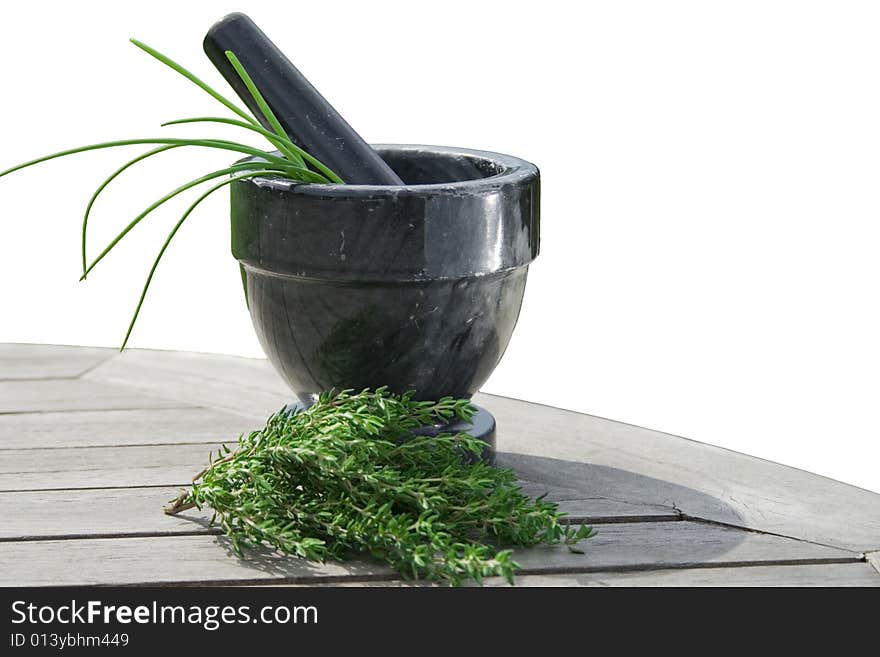 Freshly picked chives in a gray marble mortar and fresh thyme on a wooden table. Isolated. Freshly picked chives in a gray marble mortar and fresh thyme on a wooden table. Isolated.