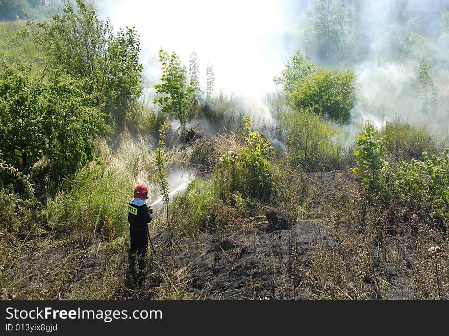 Firefighters using a hose reel jet on a heath fire. Firefighters using a hose reel jet on a heath fire