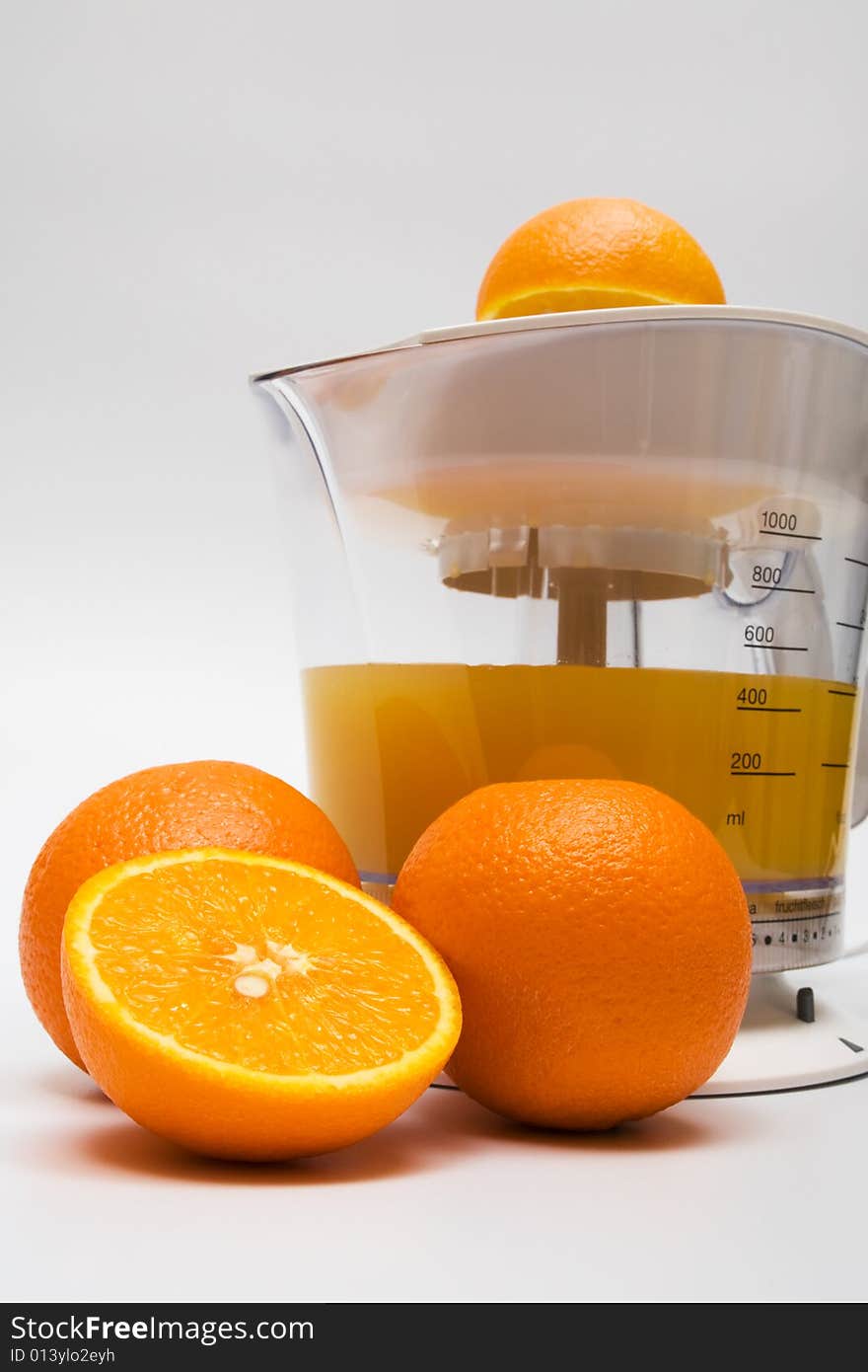 Modern juice extractor with juice and ripe oranges