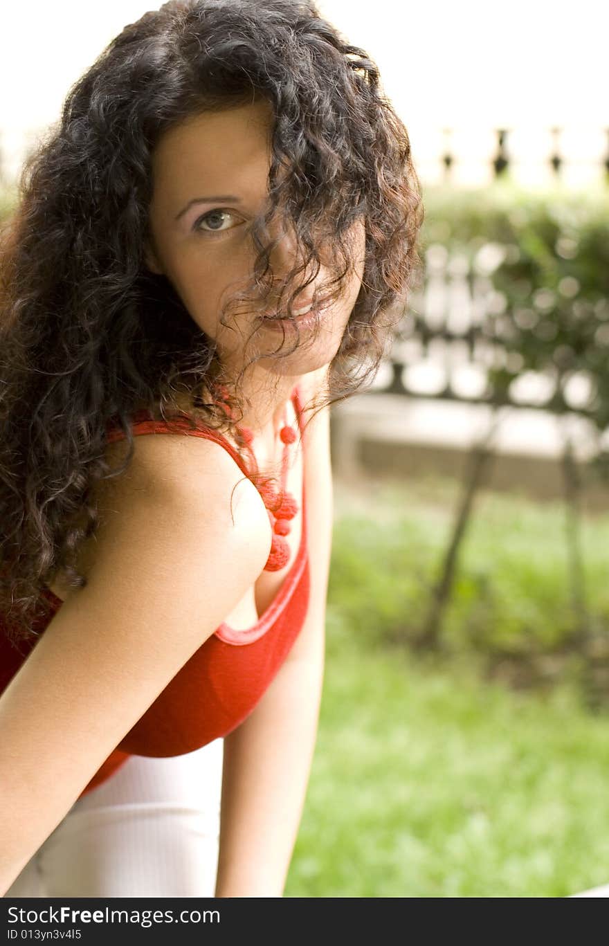 Outdoor portrait of beautiful brunet woman in red