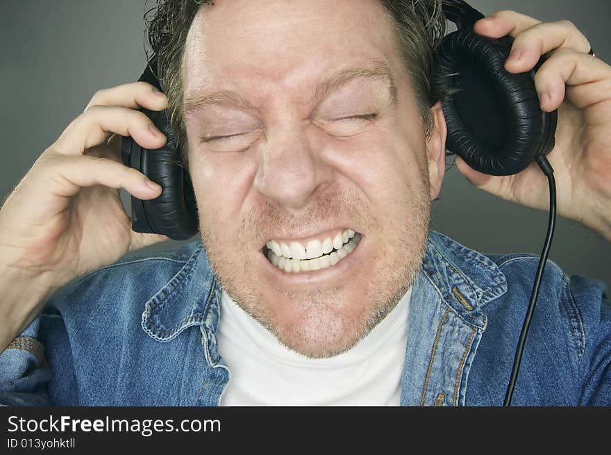 Shocked Man Desperately Pulling His Headphones Off. Shocked Man Desperately Pulling His Headphones Off.