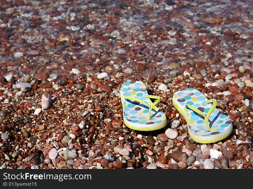 Gravel beach with flip-flops