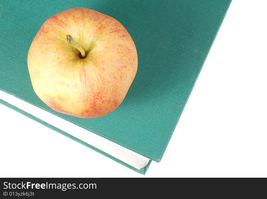 A fresh  red apple on top of a book. A fresh  red apple on top of a book