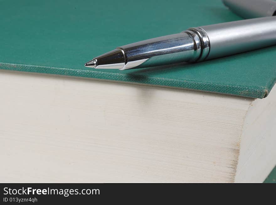 Silver pen on top an old book. Silver pen on top an old book