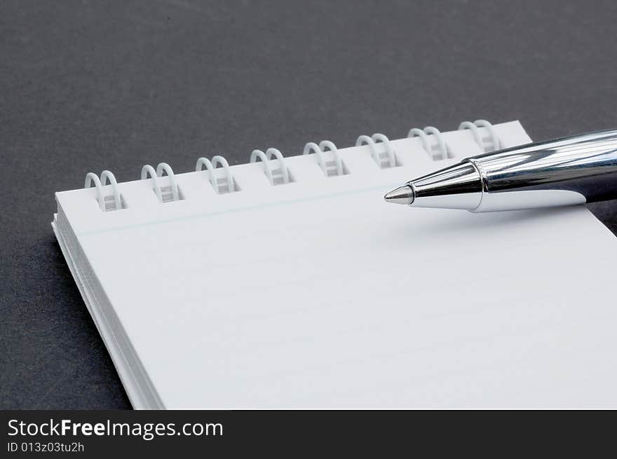 Macro shot of a pen on a small notepad. Macro shot of a pen on a small notepad