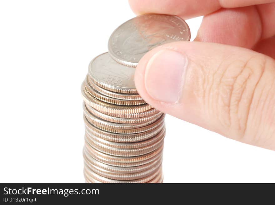 Hand building a tower of quarters isolated on a white background. Hand building a tower of quarters isolated on a white background