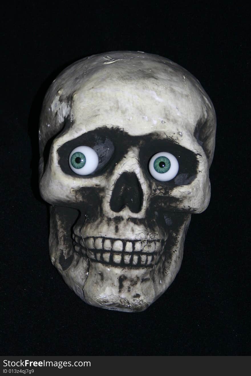 A skull with glass eyes on a black background. A skull with glass eyes on a black background.