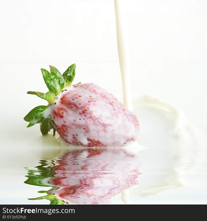 An image of red strawberry in a milk close up